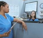Home Nurses in scrub suits discussing medical tasks in a clinical environment.